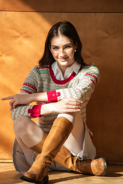 bela menina morena em uma camisola bege com um chão de madeira - Foto, Imagem