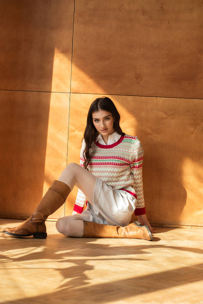 fiatal nő pózol stúdióban egy pulóver és cipő - Fotó, kép