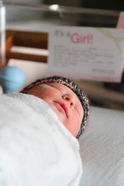 Újszülött csecsemő lány kórházi kiságyban alszik - Fotó, kép