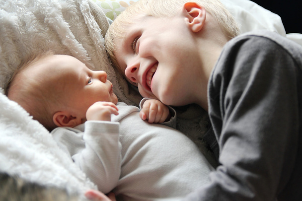 Großer Bruder betrachtet Neugeborenes mit Liebe - Foto, Bild