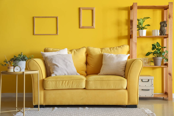 Εσωτερικό του σαλονιού με κίτρινο καναπέ και ραφιέρα - Φωτογραφία, εικόνα
