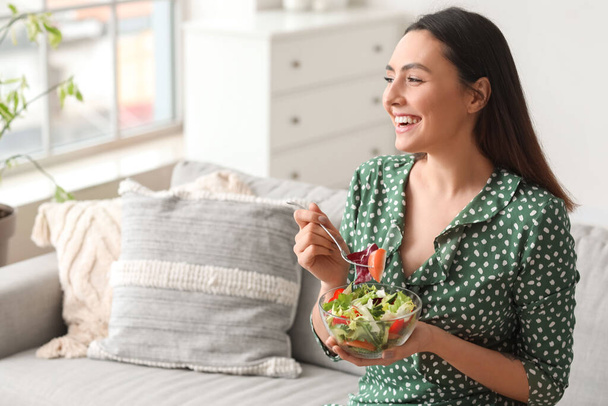 junge Frau isst Gemüsesalat zu Hause - Foto, Bild