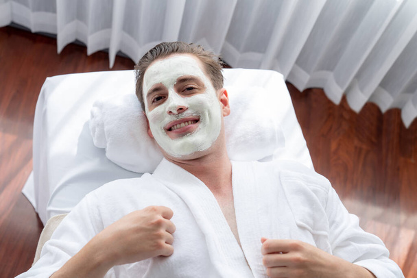 Spokojna atmosfera salonu spa, klient odmładza się luksusowym masażem kremem do twarzy z nowoczesnym światłem dziennym. Leczenie twarzy i koncepcja pielęgnacji twarzy. Cichy zapach - Zdjęcie, obraz