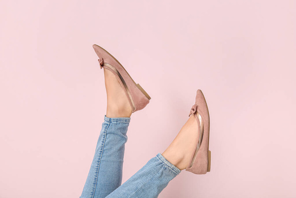 Γυναικεία πόδια σε κομψά παπούτσια στο χρώμα φόντου - Φωτογραφία, εικόνα