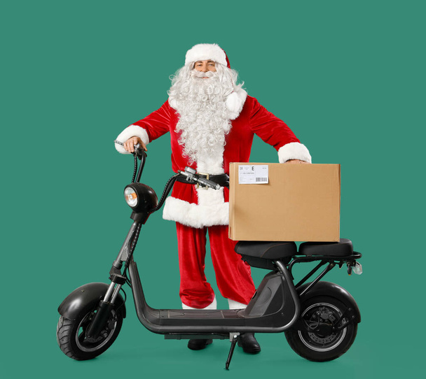 Babbo Natale con scooter elettrico e pacco su sfondo verde - Foto, immagini