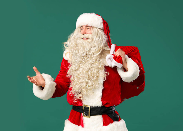 Porträt des Weihnachtsmannes mit Geschenktüte auf grünem Hintergrund - Foto, Bild