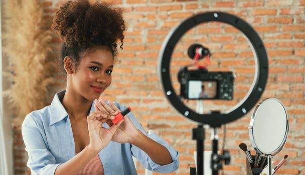 女性インフルエンサーは,ライブストリーミングビデオレビューメイクアップ重要なソーシャルメディアやブログを撮影します. オンラインでのマーケティングレコーディングセッション放送のための化粧品スタジオ照明を持つ幸せな若い少女. - 写真・画像