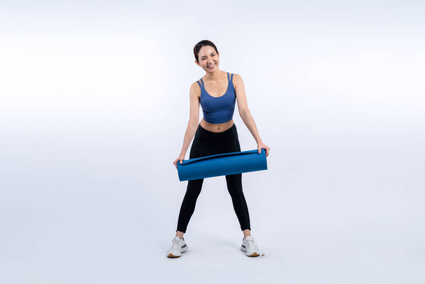 Young attractive asian woman portrait in sportswear with exercising mat. Healthy exercise and workout routine lifestyle concept. Studio shot isolated background. Vigorous - Photo, Image