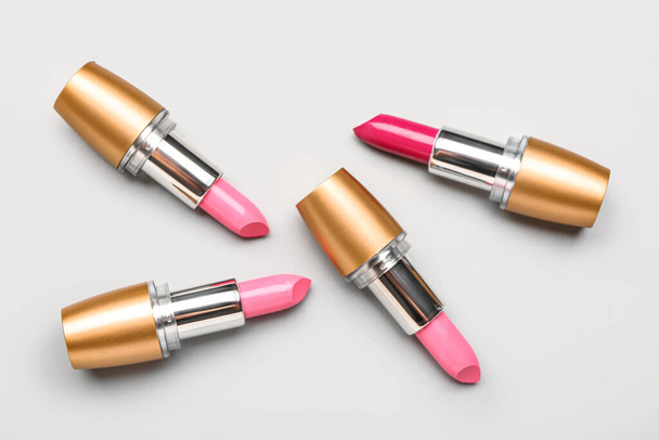 Verschillende stijlvolle roze lippenstift op lichte achtergrond - Foto, afbeelding