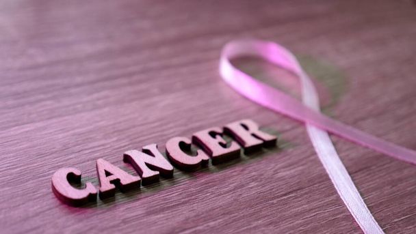 Image de fond en bois Cancer du sein La sensibilisation est célébrée en octobre Mois. L'inscription avec le symbole est un ruban rose. Gros plan - Photo, image