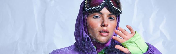 houkutteleva nainen parvekkeella, violetti talvitakki ja hiihtogoogleja poseeraa harmaa, luminen banneri - Valokuva, kuva