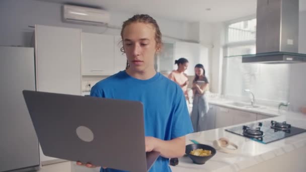 Επιλεκτική εστίαση, πορτρέτο του νεαρού άνδρα μαθητή που εργάζεται σε έργο χρησιμοποιώντας φορητό υπολογιστή στο σπίτι, κοιτάζοντας την κάμερα - Πλάνα, βίντεο