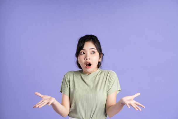 Портрет красивой азиатской девушки, позирующей на фиолетовом фоне - Фото, изображение