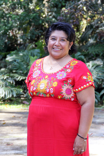 Übergewichtige brünette Latina erwachsene Frau in ihren 50ern ist glücklich und stolz auf ihre Wurzeln in traditionellen mexikanischen bestickten Kleidern - Foto, Bild