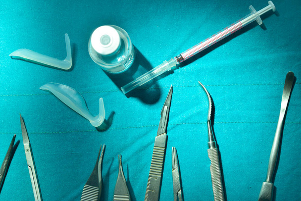 Sebészeti műszerek, szilikon orrimplantátum és szilikon állimplantátum a műtőben - Fotó, kép