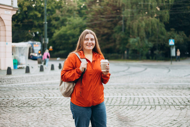 Giovane bella donna con caffè passeggiando per strada. Portare via o concetto di consegna. Copia spazio - Foto, immagini