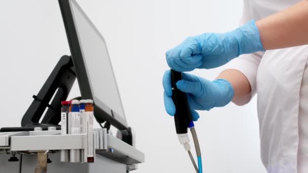Καλλιεργημένος επαγγελματίας δερματολόγος στήνει και χρησιμοποιεί τη μηχανή φλούδας προσώπου HYDRA με τα κομμάτια χεριών και καλωδίων. Περιποίηση ομορφιάς προσώπου σε κλινική σπα. Ηλεκτροτρόλυση αντιγηραντική τεχνολογία, υγιεινή - Πλάνα, βίντεο