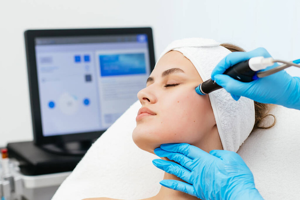 Ammattimainen naiskosmetologi tekee hydra-kasvojen toimenpiteen kosmetiikkaklinikalla. Lääkäri käyttää hydra-pölynimuria. Uudistamisen ja kosmetologian käsite - Valokuva, kuva