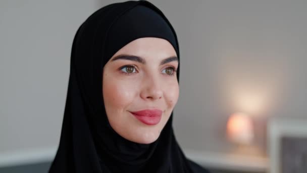 Close-up van dromerig, penetrante, gefocuste gezicht van Arabische vrouw in zwarte hijab. Gezicht van feministische islamitische vrouw met zwarte hoofddoek op het hoofd. Feminisme in Islamitische landen, Moslim Feminist, gelijke rechten. - Video