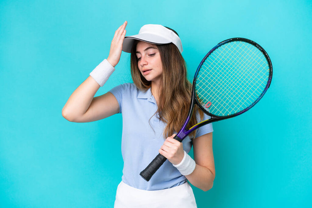 青の背景に隔離された若いテニス選手の女性は何かを実現し、解決策を意図しています - 写真・画像