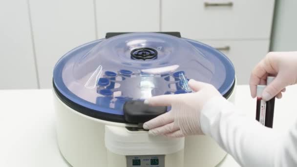 Primer plano de un químico usando una centrifugadora en el laboratorio Los tubos llenos de sangre están en la centrifugadora de elevación de plasma en el laboratorio. - Imágenes, Vídeo