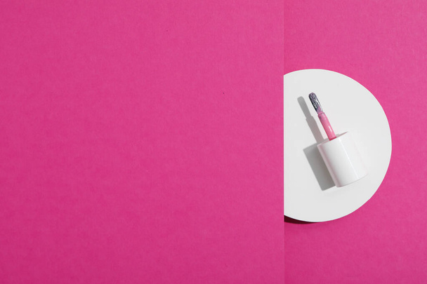 Cepillo de esmalte de uñas sobre fondo rosa - Foto, imagen