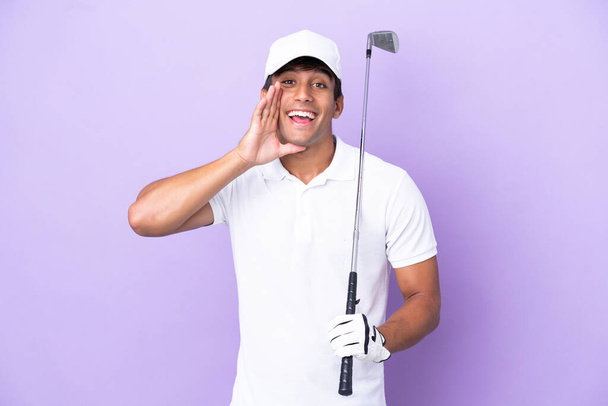 Mor arka planda izole edilmiş genç beyaz adam golf oynuyor ve ağzı açık bağırıyor. - Fotoğraf, Görsel