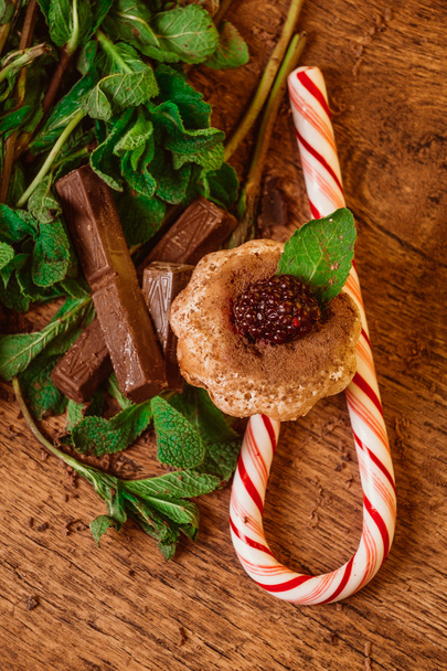 peppermint candy chocolate muffin with blackberries and mint on a wooden table - Photo, Image