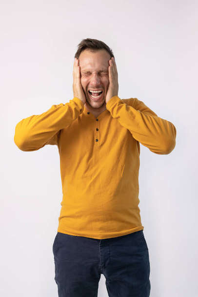 Középkorú férfi sárga pulóvert visel őrült és őrült kiabálás és kiabálás agresszív kifejezés és zárt fülek.  - Fotó, kép