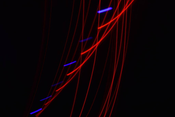 Larga exposición colorida línea abstracta pintura fondo aislado en negro. líneas curvas de iluminación de tira led sobre fondo negro  - Foto, Imagen