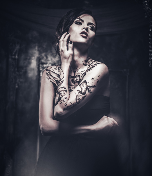 Татуированная красивая женщина в старом жутком интерьере
 - Фото, изображение