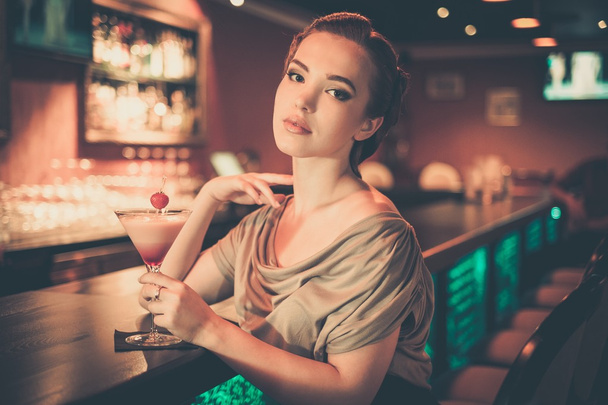 Kaunis nainen iltapuku istuu lähellä baari laskuri
 - Valokuva, kuva