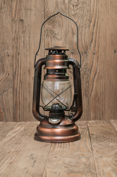 Lâmpada de querosene em um fundo de madeira
 - Foto, Imagem