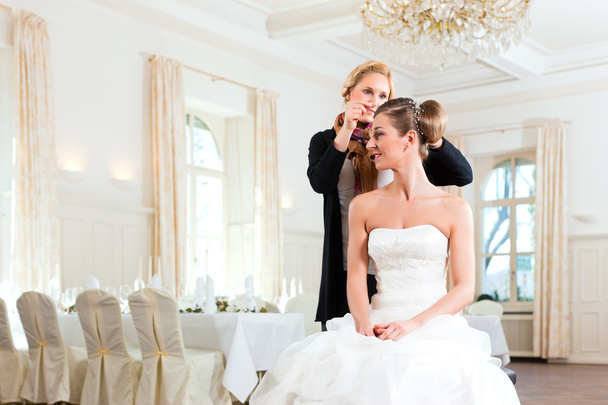 stylist pinning omhoog van een bruid kapsel - Foto, afbeelding