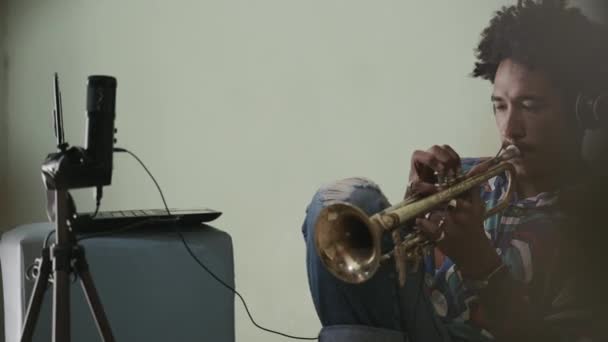 Nuori afroamerikkalainen mies äänittää musiikkia, soittaa latinalaista jazzia trumpettia  - Materiaali, video