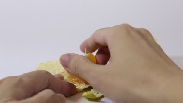 Κάποιος ξεφλουδίζει πορτοκάλια για φαγητό - Πλάνα, βίντεο
