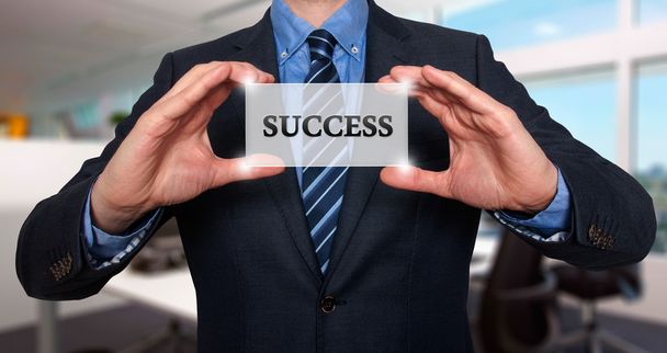Бизнесмен держит белую карточку со знаком успеха - Stock PImage
 - Фото, изображение