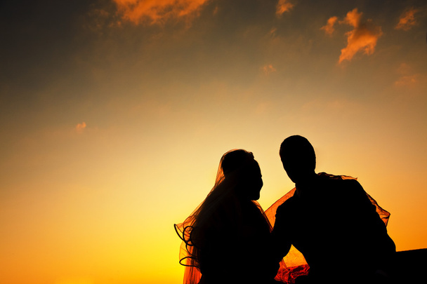 Silueta romántica de pareja de boda al atardecer
 - Foto, Imagen