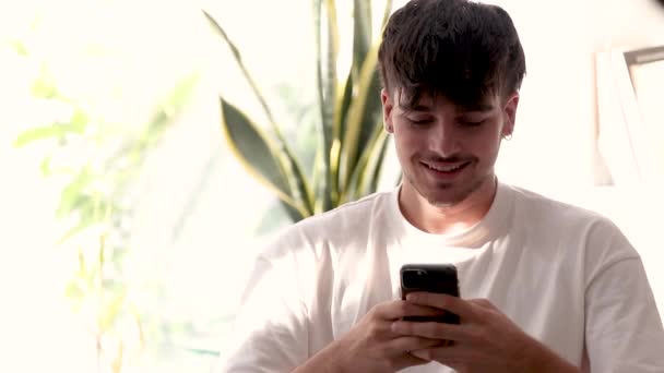 Młody człowiek z telefonem komórkowym reaguje z sukcesem w zwolnionym tempie - Materiał filmowy, wideo
