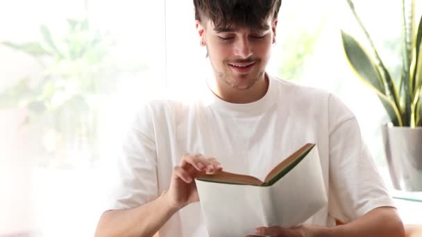 mladý muž studuje nebo čte učebnici - Záběry, video