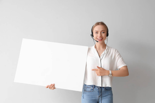 Жіночий агент технічної підтримки з порожнім плакатом на світлому фоні - Фото, зображення