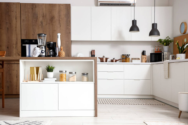 Interior de cocina ligera con electrodomésticos modernos en mesa de madera - Foto, imagen