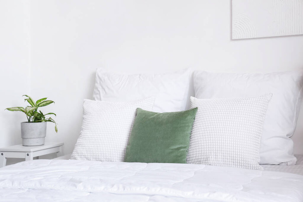 Beyaz battaniyeli rahat bir yatak ve hafif yatak odasında yastıklar. - Fotoğraf, Görsel