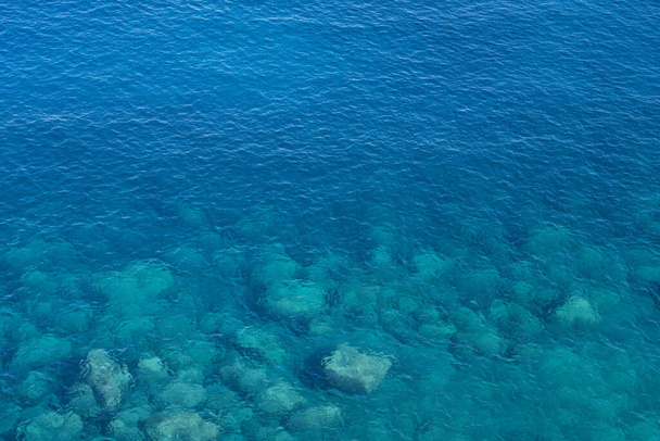 tło, tekstura przezroczysta woda z kamieniami na dnie morza - Zdjęcie, obraz