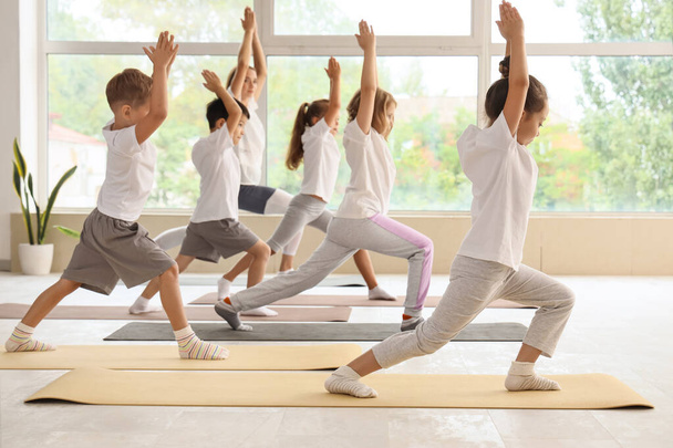 Grupo de niños pequeños practicando yoga en el gimnasio - Foto, imagen