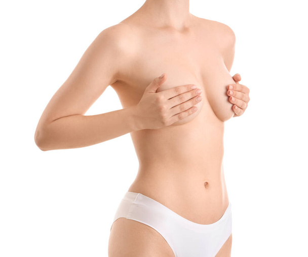 Молодая женщина покрывает грудь на белом фоне - Фото, изображение
