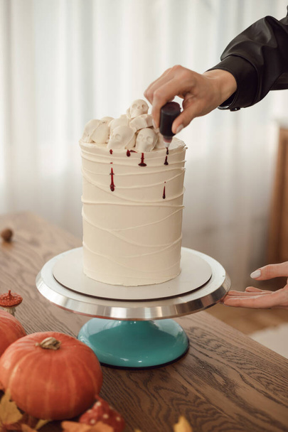 onfectioner mujer decora un pastel con sangre para Halloween. Idea de pastel - Foto, Imagen