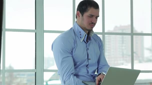 Üzleti a laptop. Vidám és sikeres üzletember, a hivatalos viselet ül egy laptop tartja a kezében a pultnál - Felvétel, videó