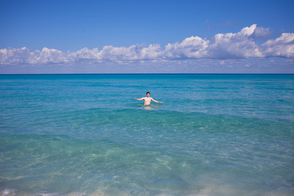 Raising His Hands man swims in the sea, on distance - Valokuva, kuva