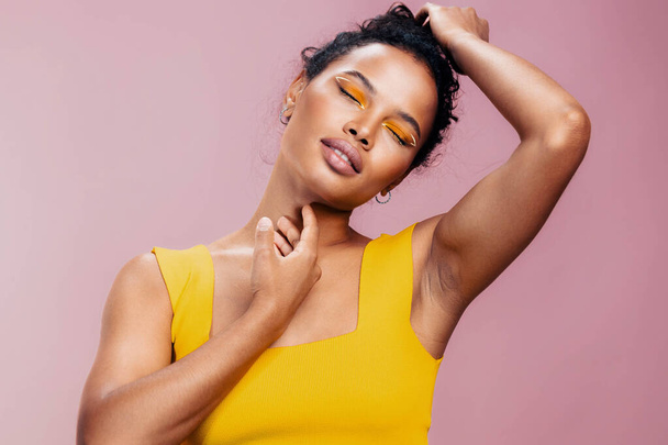 スタジオ女性黒ピンクの肖像化粧品スペース化粧品エスニッククリエイティブスタイルメイクアップモデル美しい肌アフリカのコピーアイ美しさファッションカラフルな黄色の笑顔 - 写真・画像